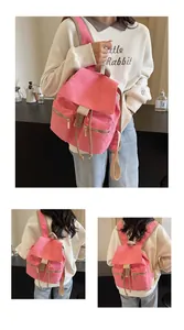 Detalle de la mochila de lona rosa tipo cubo con cordón y detalles de correas marrones