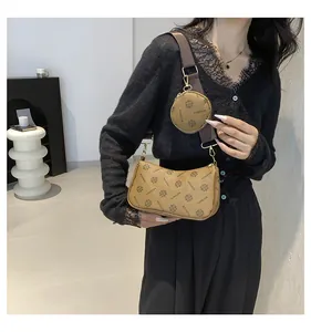 Close-up of retro brown 2-in-1 crossbody bag with logo pattern and wide shoulder strap