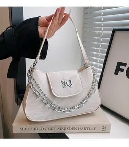 Detail of white marble pattern handbag with silver butterfly buckle and chain strap