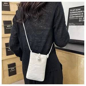 Vista dettagliata della mini borsa bianca con chiusura a perla e tracolla intrecciata