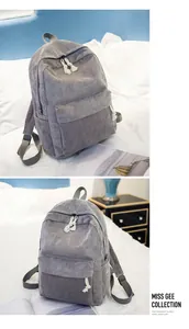 Detail view of grey corduroy backpack with vertical texture and cotton rope zippers