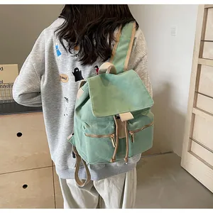 Detalle de la mochila de lona verde menta con cremalleras metálicas y correas tejidas detrás