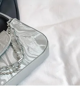 Detailed macro view of silver iridescent marble texture and dual metal chains on handbag