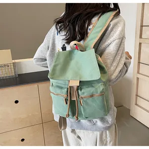 Detalle de la mochila de lona verde fruta con cordón vintage y cremalleras doradas