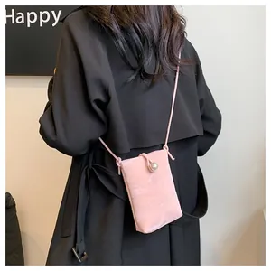 Dettaglio della mini borsa a tracolla rosa chiaro con trama marmorea e chiusura a perla su cappotto