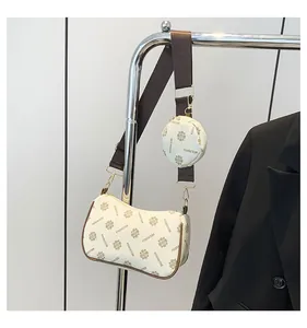 Close-up of white crossbody bag with vintage brown pattern and round coin purse attachment