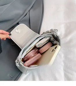 Interior detail showing ample storage space for a phone and makeup in this silver shoulder bag