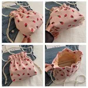 Détails du sac seau en velours rose à fraises avec chaîne de perles et cordon de serrage