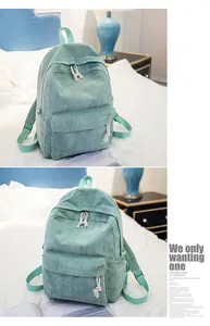 Detail of mint green corduroy backpack with striped texture and front zipper pocket