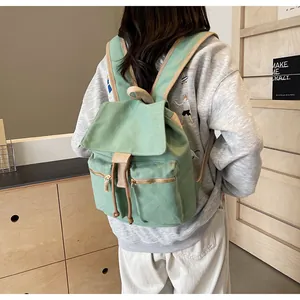 Vista trasera de la mochila de lona verde salvia con doble cremallera y cordón ajustable