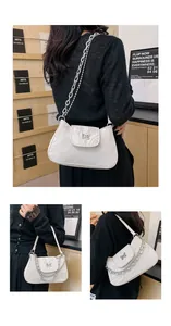 Detail of white marble textured underarm bag featuring a metallic butterfly clasp and chain
