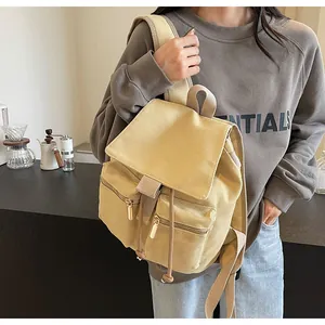Detalle de mochila de lona con cordón y bolsillos delanteros vintage en sudadera gris