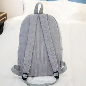 Minimalist grey corduroy backpack with wide adjustable straps on a white background