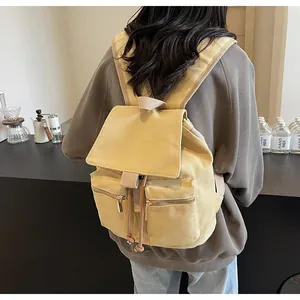 Detalle de una mochila de lona beige con bolsillos dobles delanteros de estilo vintage
