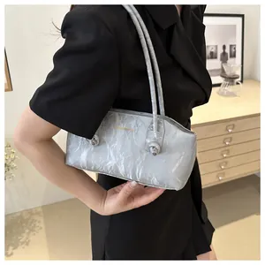 Detail of silver pleated faux leather underarm bag with knotted strap handles