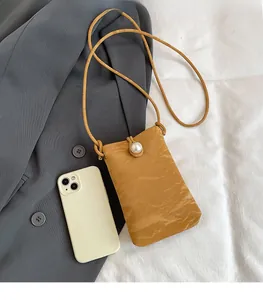 Mini borsa per telefono gialla con trama a pieghe e grande perla come decorazione
