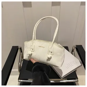 Detail view of cream handbag featuring pleated leather texture and stylish knot handle