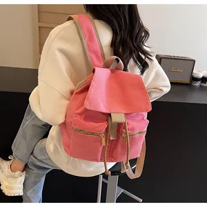 Detalle de la mochila tipo cubo en lona rosa con cremalleras doradas dobles