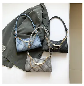 Détail de sacs bandoulière en denim vintage avec perles blanches et chaîne dorée chic