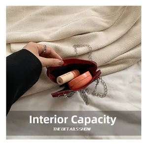 Capacité interne du mini sac en cuir rouge contenant du rouge à lèvres et du poudrier