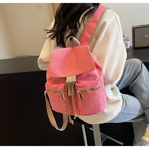 Detalle de mochila de lona rosa con dos bolsillos con cremallera y cierre de cordón ajustable