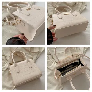 Detail views of cream faux-crocodile handbag showing interior space and metal hardware