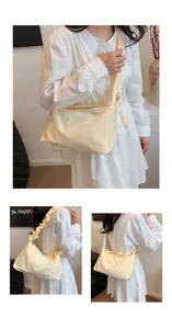 Detail der cremefarbenen Plissee-Stofftasche mit strukturierter Oberfläche und Tragegurt