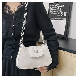 Detail of faux marble shoulder bag featuring silver butterfly clasp and metal chain strap
