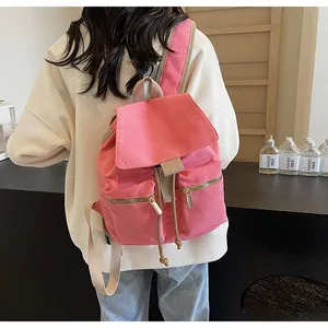Detalle de mochila de lona rosa con bolsillos de cremallera y correas en color crema