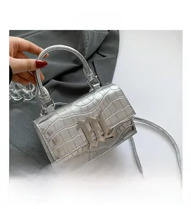 Detail der silbernen Kunstledertasche mit Kroko-Prägung und gotischem Metall-Logo