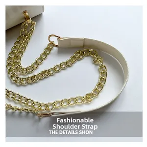 Detail of white leather shoulder strap with gold chain links and metallic clasps