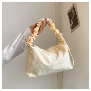 Detail des weichen Scrunchie-Griffs und des Faltenstoffs an der cremefarbenen Canvas-Tasche