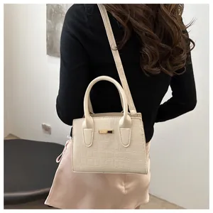 Back view of a model wearing a cream stone pattern mini handbag with gold plaque