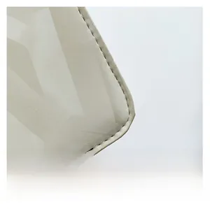 Detail of premium cream faux leather square bag featuring elegant geometric letter patterns