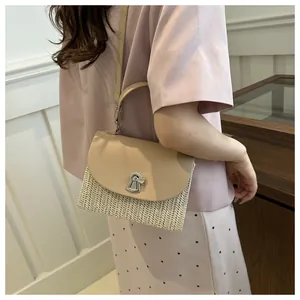 Detail of straw patchwork crossbody bag with beige leather flap and silver twist lock closure