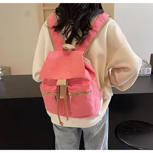 Mochila de lona rosa con correas ajustables marrones y bolsillos con cremallera dorados