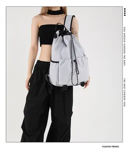 Détail du sac à dos en nylon imperméable avec cordon de serrage et poches en gris clair