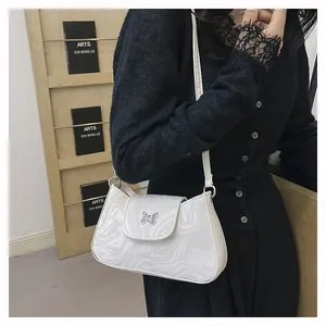Detail of white marble textured shoulder bag with silver butterfly metal buckle design