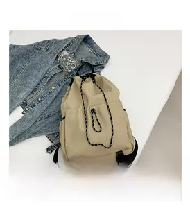 Détail d'un sac à dos seau en nylon kaki avec fermeture à cordon et poches fonctionnelles