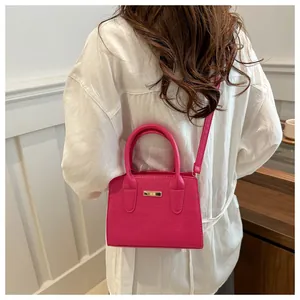 Detailed back view of a model wearing a rose pink crocodile-embossed rectangle handbag