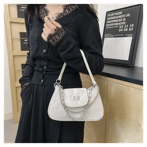 Close-up of marble texture shoulder bag featuring a metal butterfly clasp and chain detail