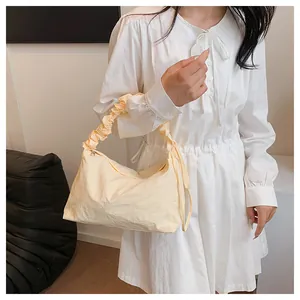 Detail der weichen cremefarbenen Canvas-Tasche mit plissiertem Griff und Tunnelzug