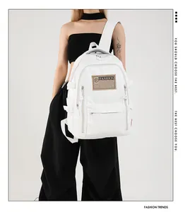 Detailed view of white PU leather backpack featuring multiple zipper compartments and buckles