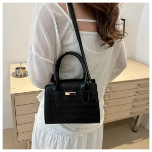 Detailed back view of model wearing black stone pattern handbag with gold clasp