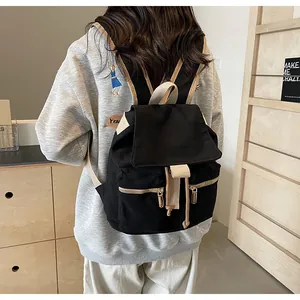 Detalle de mochila vintage de lona con cierre de cordón y correas en contraste