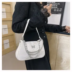 Detail of white marble pattern shoulder bag with silver butterfly clasp and chains