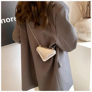 Détail du sac à chaîne triangulaire argenté avec logo JINGPIN embossé sur surface métal