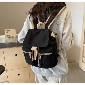 Detalle de la mochila tipo saco en lona negra con cordón beige y cremalleras doradas