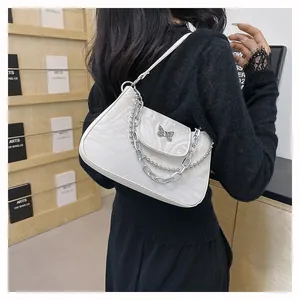 Detail of white marble textured shoulder bag featuring silver butterfly metal buckle
