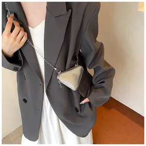 Détail du mini sac bandoulière triangulaire argenté avec finition métallique et chaîne